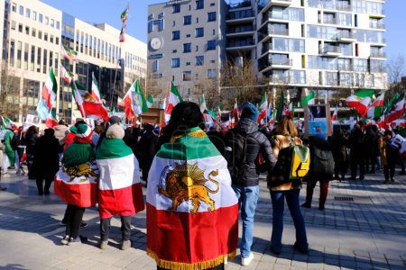 Téléchargez les photos : Les manifestants arborent le drapeau de la révolution pré-islamique de 1979 alors qu'ils participent à une manifestation soutenant le mouvement de résistance iranien à Bruxelles le 1er mars 2023. - en image libre de droit