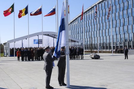 Téléchargez les photos : Des militaires finlandais installent le drapeau national finlandais au siège de l'OTAN à Bruxelles, en Belgique, le 04 avril 2023. - en image libre de droit