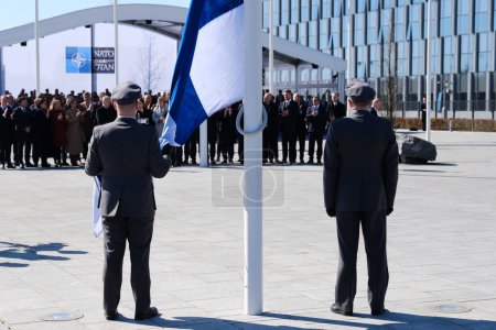 Téléchargez les photos : Des militaires finlandais installent le drapeau national finlandais au siège de l'OTAN à Bruxelles, en Belgique, le 04 avril 2023. - en image libre de droit