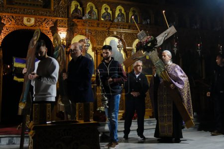 Foto de Un sacerdote lleva la Santa Cruz durante la ceremonia especial de la crucifixión de Jesucristo en la Iglesia ortodoxa en Platy, Grecia, el 13 de abril de 2023. - Imagen libre de derechos