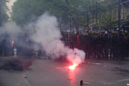 Photo for Riot police uses tear gas to disperse the crowd during the May Day labour march, a day of mobilisation against the French pension reform law and for social justice, in Paris, France May 1, 2023. - Royalty Free Image