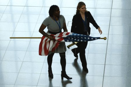 Téléchargez les photos : Une femme porte un drapeau américain avant une conférence de presse à la fin de la réunion des ministres de la Défense de l'OTAN au siège de l'OTAN à Bruxelles, en Belgique, le 16 juin 2023. - en image libre de droit