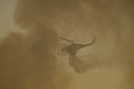 Téléchargez les photos : Un hélicoptère de lutte contre les incendies fait une chute d'eau alors qu'un feu de forêt brûle dans la banlieue d'Athènes, en Grèce 22 août 2023. - en image libre de droit