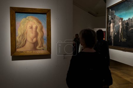 Téléchargez les photos : Les visiteurs regardent des peintures d'artistes surréalistes lors de l'exposition "Le surréalisme en Belgique" au Musée Bozar à Bruxelles, Belgique, le 6 avril 2024. - en image libre de droit
