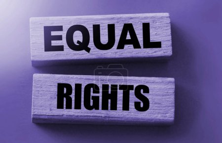 Foto de Igualdad de derechos, palabras sobre bloques de madera sobre fondo rojo. Concepto social de igualdad. - Imagen libre de derechos