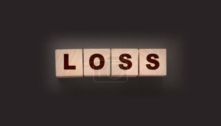 Foto de Cubos de madera con palabra perdida en la mesa negra. Concepto de negocio de pérdidas financieras. - Imagen libre de derechos