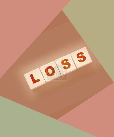 Foto de Cubos de madera con palabra perdida en la mesa negra. Concepto de negocio de pérdidas financieras. - Imagen libre de derechos