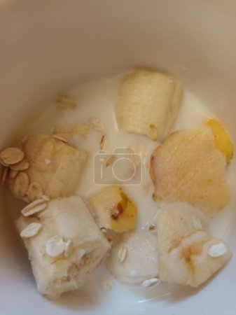 Téléchargez les photos : Tranches de banane et lait dans un bol - en image libre de droit