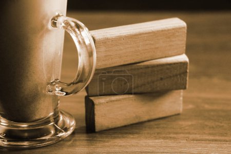 Photo for Stack of wooden cubes on table next to cup - Royalty Free Image