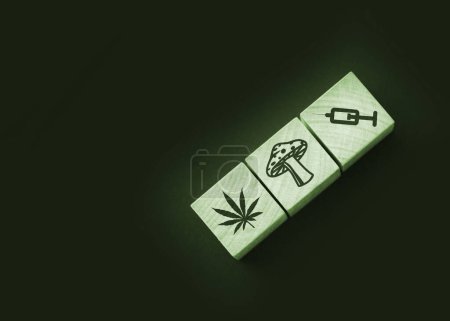 Foto de Iconos de drogas en cubos de madera natural. Hoja de cannabis, champiñones y jeringa en bloques de madera. - Imagen libre de derechos
