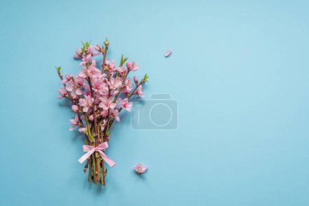 Foto de Spring bouquet. Greeting card spring flowers. Branches with flowers on a blue background - Imagen libre de derechos