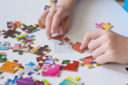 Foto de The child collects puzzles. Hobby. Classes for children. - Imagen libre de derechos