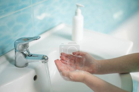 Foto de El niño se lava las manos con jabón
. - Imagen libre de derechos