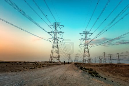 Téléchargez les photos : Haute tension une tour électrique à l'heure du coucher du soleil près du désert d'Al Hofuf - Arabie Saoudite. - en image libre de droit