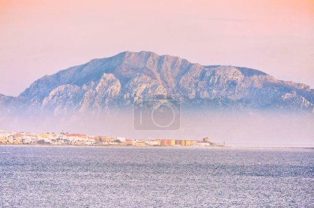 Photo for Musa mountain in tarifa sea with fog and sunrise colors calm sea beautiful landscape - Royalty Free Image