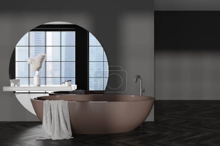Téléchargez les photos : Intérieur salle de bain sombre avec baignoire et accessoires de bain, grand miroir sur mur gris, plancher de bois franc. Fenêtre panoramique sur les gratte-ciel. rendu 3D - en image libre de droit
