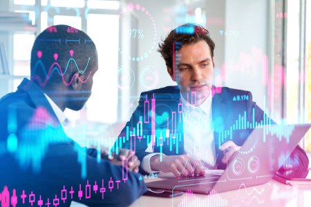 Foto de Two businessmen working together, forex diagrams hologram and big business data analysis. Double exposure hologram with candlesticks and chart. Concept of teamwork and trading - Imagen libre de derechos