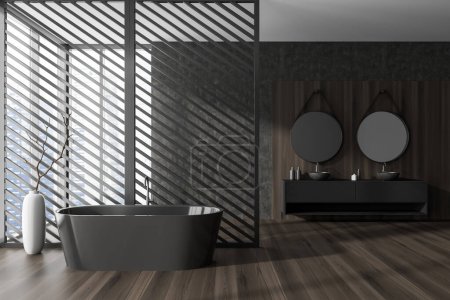 Téléchargez les photos : Intérieur salle de bain sombre avec baignoire et cloison, double lavabo avec armoire et parquet. Fenêtre panoramique sur les gratte-ciel. rendu 3D - en image libre de droit