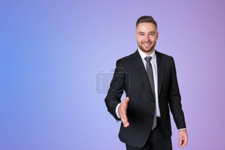 Photo for Happy businessman in black formal suit, stretching out a hand to shake on copy space purple gradient background. Concept of business agreement and partnership - Royalty Free Image