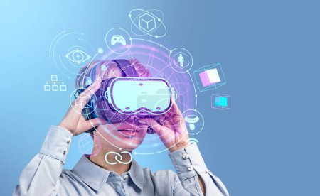 Foto de Businesswoman working in vr glasses, metaverse hologram hud with accessories icons. Online connection and digital world. Concept of virtual reality - Imagen libre de derechos