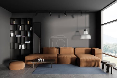 Foto de Interior de la sala de estar oscura con sofá en el suelo de baldosas de hormigón gris. Estante con decoración y ventana panorámica al campo. Mockup pared de espacio de copia vacía. Renderizado 3D - Imagen libre de derechos