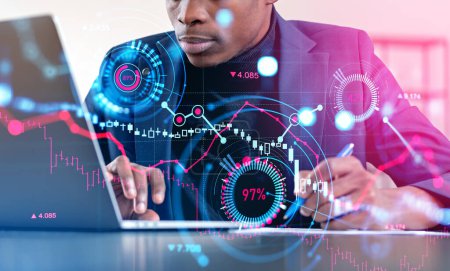 Foto de Black businessman take note and working with laptop, double exposure with forex diagrams and candlesticks up and down hologram. Concept of trend analysis - Imagen libre de derechos