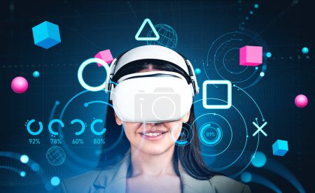 Photo for Smiling businesswoman wearing formal wear and vr headset watching at metaverse reality with blockchain system. Dark background, pie diagrams, spheres. Concept of modern technology and virtual game - Royalty Free Image