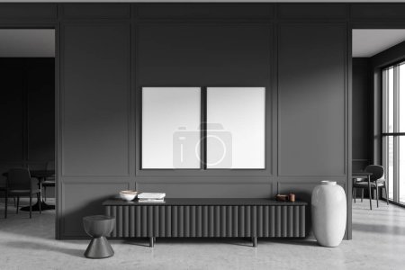 Foto de Dark living room interior with sideboard on grey concrete floor. Dining table and chairs on background, arch door and panoramic window. Two mockup canvas posters. 3D rendering - Imagen libre de derechos