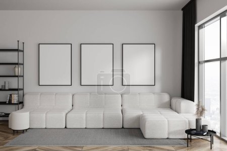 Foto de Modern living room interior with sofa, coffee table and shelf with decoration. Panoramic window on city view. Three mock up canvas posters in row. 3D rendering - Imagen libre de derechos