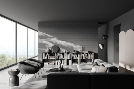 Téléchargez les photos : Dark living room interior with sofa, armchairs and coffee table on carpet, grey concrete floor. Shelf with books and panoramic window on countryside. 3D rendering - en image libre de droit