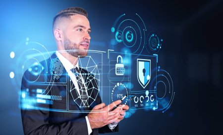 Foto de Dreaming handsome businessman wearing formal wear standing holding smartphone with digital interface with hud in background. Concept of cybersecurity, data and information protection, cyberattack - Imagen libre de derechos