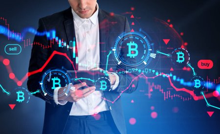 Foto de Businessman working with tablet, virtual screen with falling bitcoin, red candlesticks and glowing lines hud. Concept of crisis and cryptocurrency. - Imagen libre de derechos