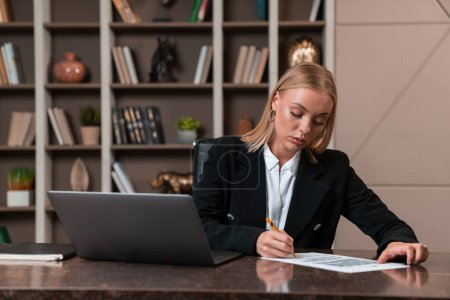 Photo for Thoughtful attractive businesswoman wearing formal wear sitting singing contract at office workplace in background. Concept of model, pondering business person, considered woman, information, lawyer - Royalty Free Image