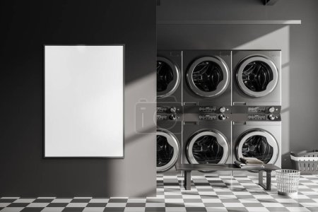 Téléchargez les photos : Dark laundry interior with grey washing machines in row, bench with basket on chess tile floor. Partition and mock up canvas poster. 3D rendering - en image libre de droit