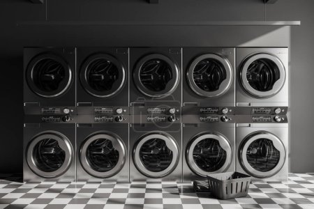 Photo for Dark laundry interior with row of grey washing machines and basket, chess tile floor. Modern public laundromat. 3D rendering - Royalty Free Image