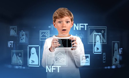 Foto de Child boy with phone in hands, open mouth looking at the camera. Digital hologram with NFT art, digital gallery tour and museum. Concept of cryptoart and metaverse - Imagen libre de derechos
