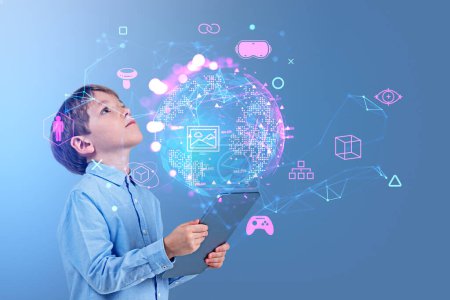 Foto de Child boy with tablet in hands, look up at earth sphere hologram with glowing icons. Virtual reality connection hud hologram, nft and online games. Concept of metaverse and technology - Imagen libre de derechos