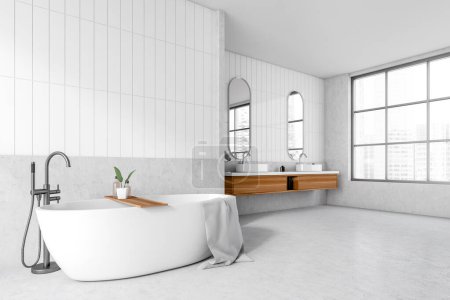 Foto de Corner view on bright bathroom interior with bathtub, panoramic window with city view, stool with shampoo and towels, mirrors, sinks, white walls, concrete floor. 3d rendering - Imagen libre de derechos
