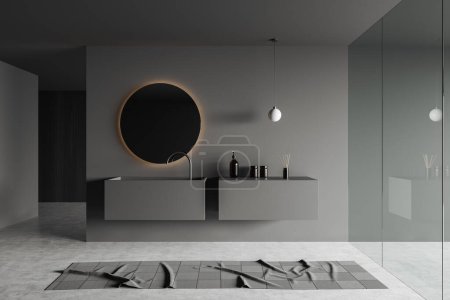 Téléchargez les photos : Dark bathroom interior with sink and round mirror with backlight, grey concrete floor with carpet. Glass doors and bathing accessories on deck. 3D rendering - en image libre de droit