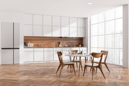 Téléchargez les photos : Corner view on bright kitchen room interior with dining table with chairs, panoramic window, cupboard, fridge, white wall, sink, oak wooden floor. Concept of minimalist design. 3d rendering - en image libre de droit