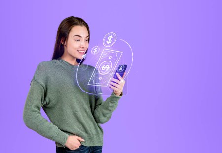 Téléchargez les photos : Woman smiling with smartphone in hand, cashback hud hologram and transaction, purple background. Concept of refund and payment - en image libre de droit