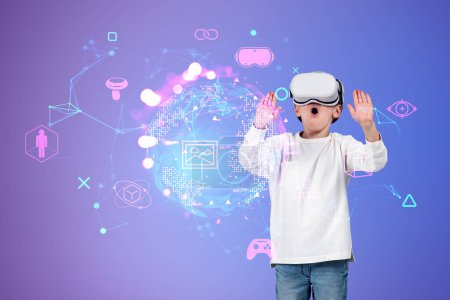 Téléchargez les photos : Boy wearing casual wear and vr googles touching metaverse reality with sketch hologram of gamepad, virtual globe. Concept of futuristic technology, virtual reality and progressive kids in business - en image libre de droit