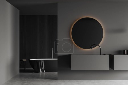 Photo for Dark bathroom interior with sink and round mirror, bathtub with towel in the corner on grey concrete floor. Modern hotel washing room. 3D rendering - Royalty Free Image