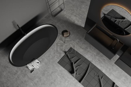 Téléchargez les photos : Top view of bathing room interior with bathtub on grey concrete floor. Washing room with tub, sink with mirror and table with towel. 3D rendering - en image libre de droit