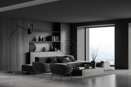 Photo for Dark living room interior with sofa and armchairs, side view, coffee table with art decoration, carpet on grey concrete floor. Panoramic window on countryside. 3D rendering - Royalty Free Image