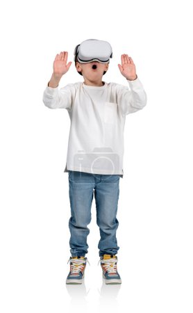 Foto de Excited child boy wearing vr glasses headset. Full length of a kid hands touching something in metaverse. Isolated over white background. Concept of digital world - Imagen libre de derechos