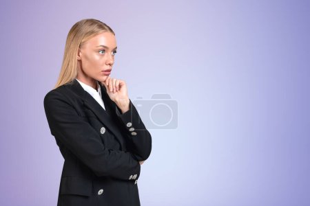 Téléchargez les photos : Femme d'affaires en costume formel noir debout avec regard coûteux, espace de copie fond violet. Femme concentrée avec la main au menton. Concept d'idée et plan - en image libre de droit
