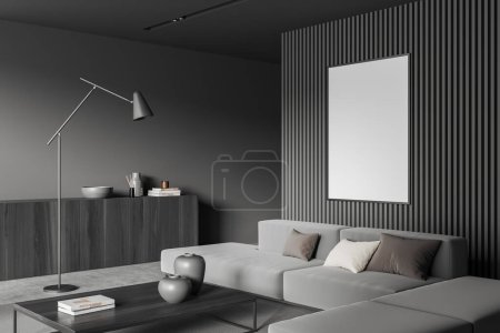 Foto de Dark living room interior with sofa and coffee table on grey concrete floor. Chill space and drawer with decoration, side view, mockup poster. 3D rendering - Imagen libre de derechos