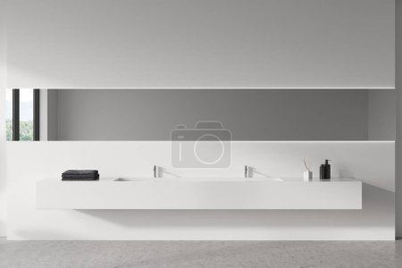 Foto de Vista frontal en el interior del baño luminoso con gran espejo largo con campo en reflexión, lavabo, paredes blancas, suelo de hormigón, jabón líquido, toallas, grifo. renderizado 3d - Imagen libre de derechos