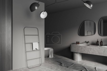 Foto de Interior de baño oscuro con lavabo y espejo, bañera y escalera de toalla, vista lateral, alfombra en piso de hormigón gris. Rincón de lavado en apartamento. Renderizado 3D - Imagen libre de derechos